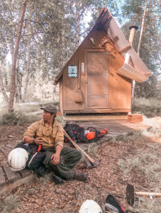 Firefighter seated on ground with pack